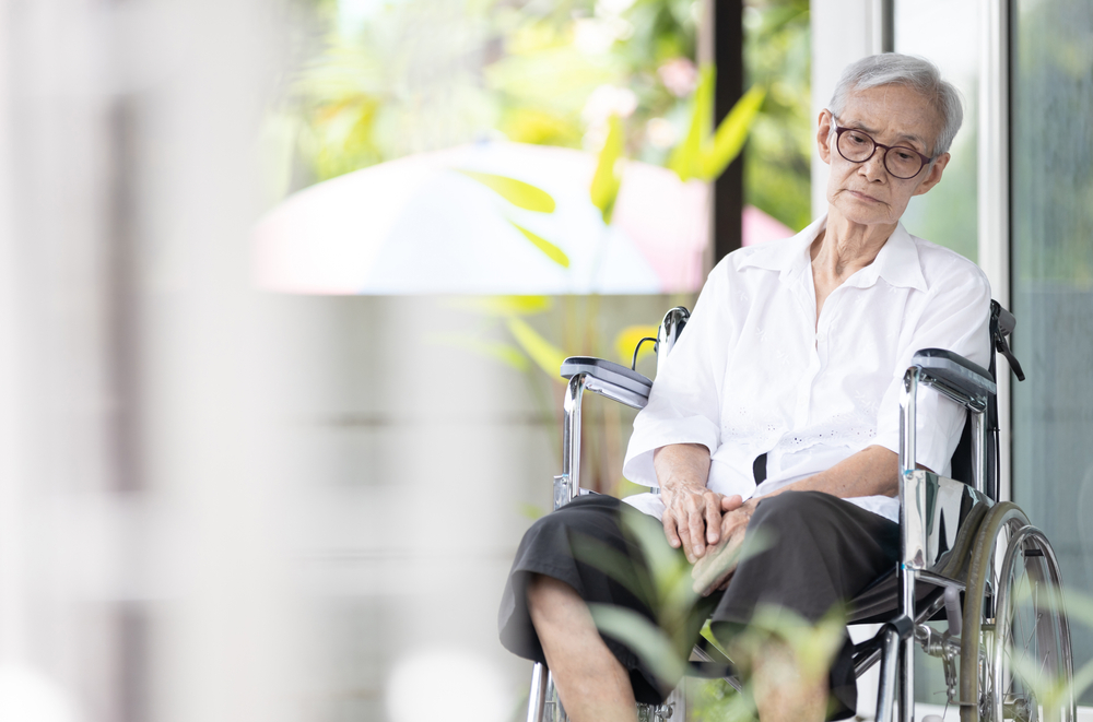 Sad,And,Depressed,Asian,Senior,Woman,Sitting,Alone,In,Wheelchair